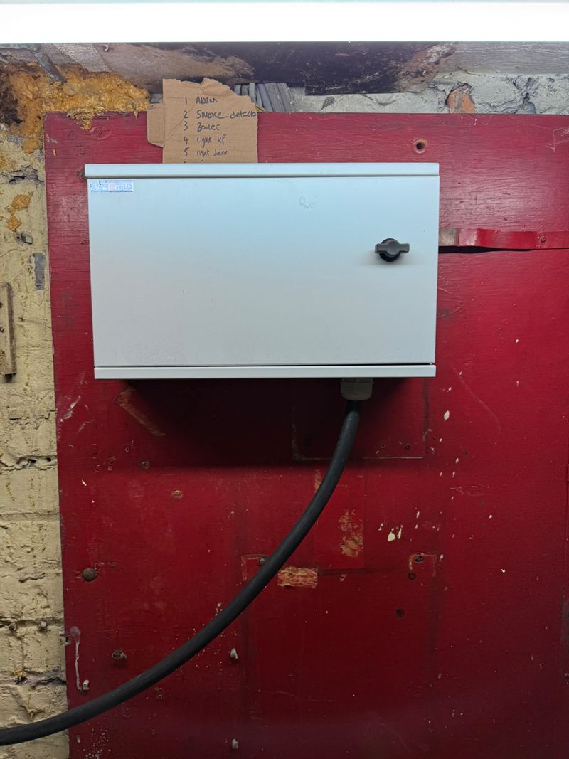 The closed enclosure with the circuit schedule listing the alarm, smoke detection, boiler and lighting circuits.